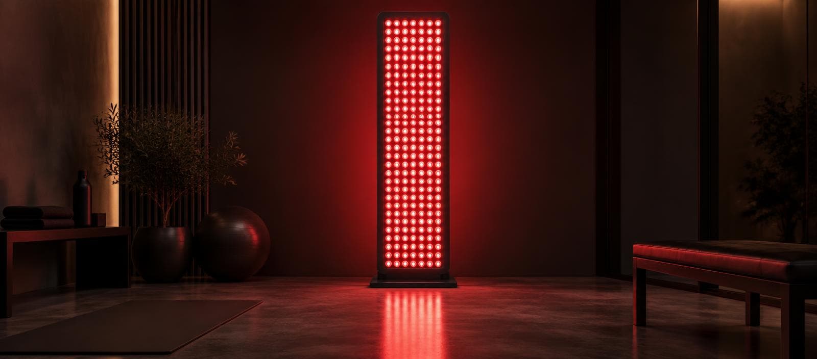 Red-light therapy panel glowing in a dark wellness room